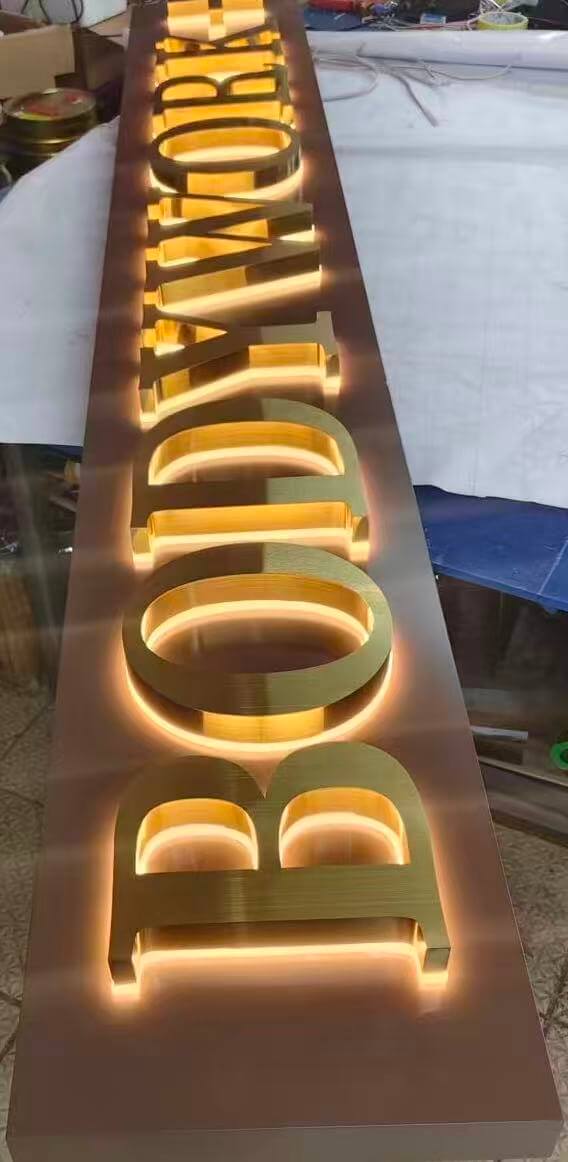 Reverse halo lit logo sign glowing on a storefront wall at night