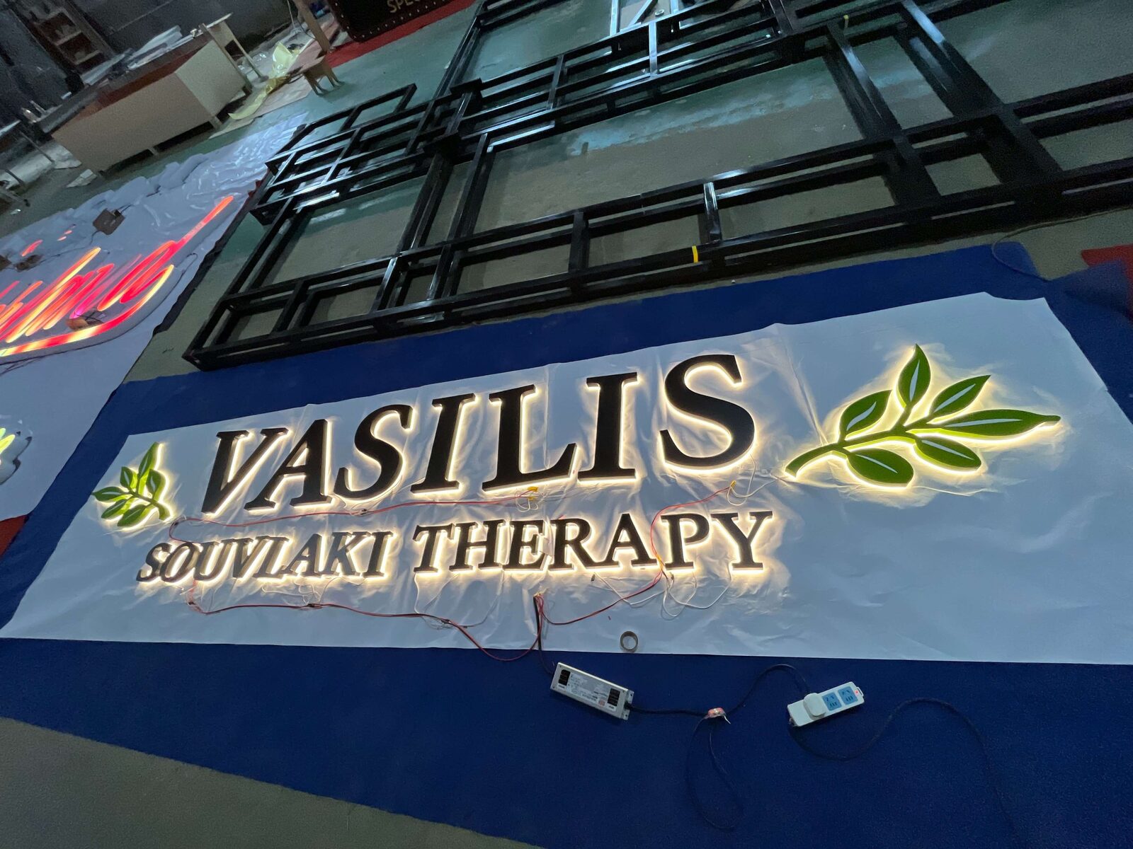 Custom restaurant backlit sign darkroom quality testing at EndPoint Sign's Guangzhou engineering center