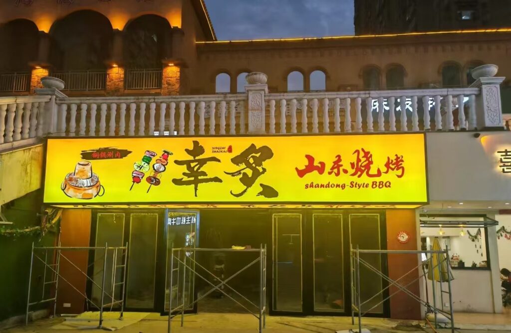 Restaurant storefront light box sign lit at night