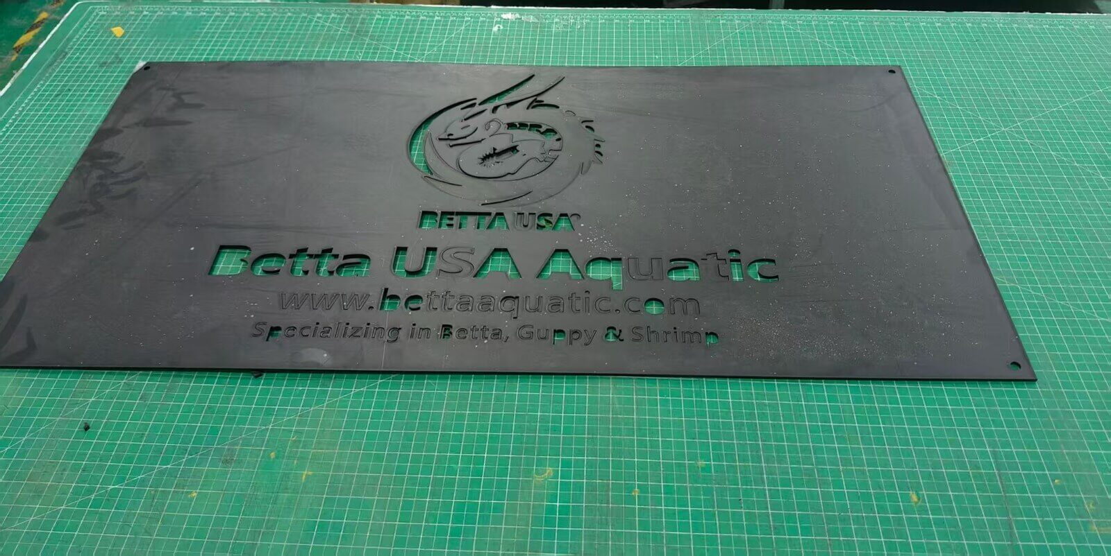 Raw dark acrylic base plate prepared for cutting and engraving at EndPoint Sign factory