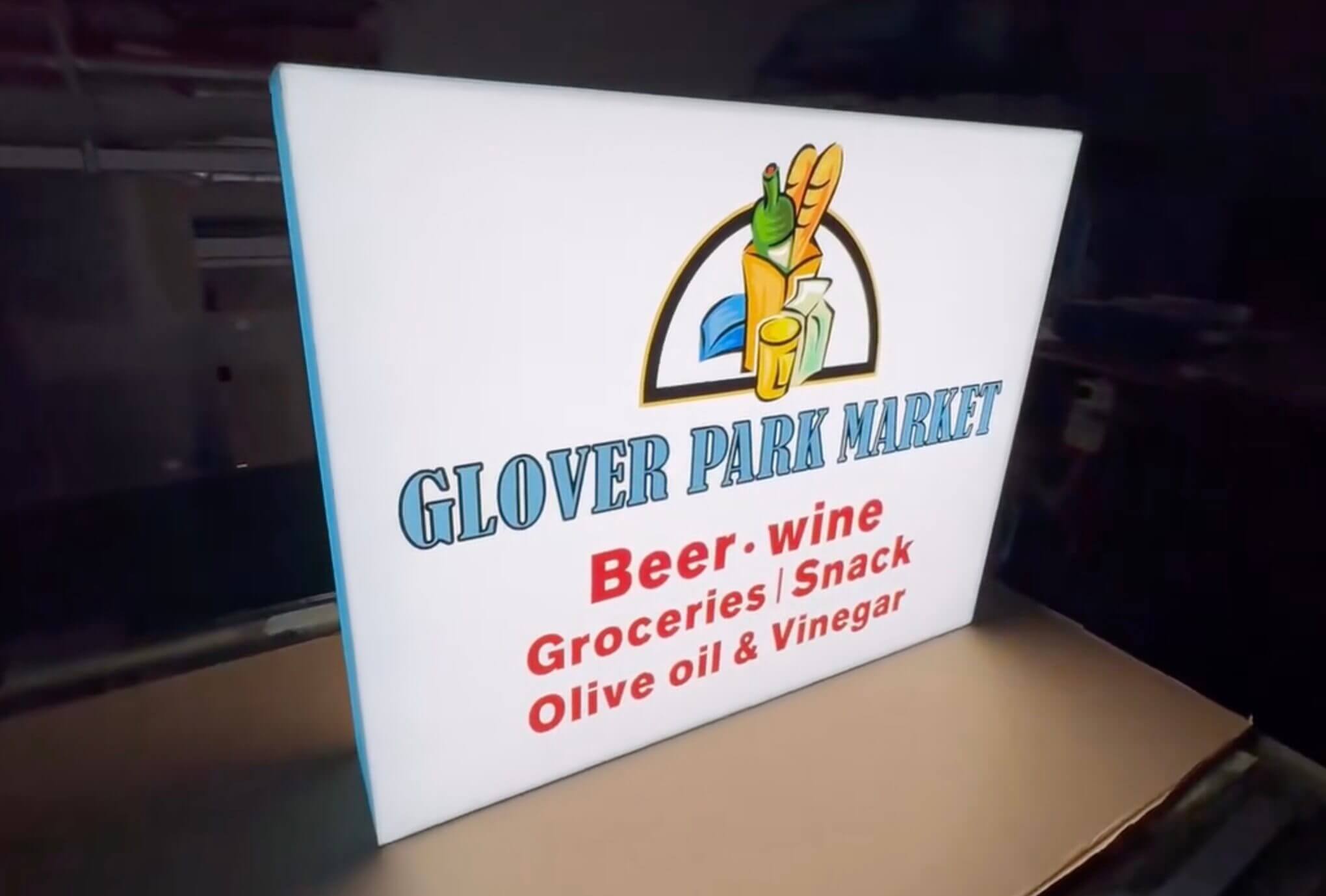 Completed custom double-sided blade sign illuminated test in workshop